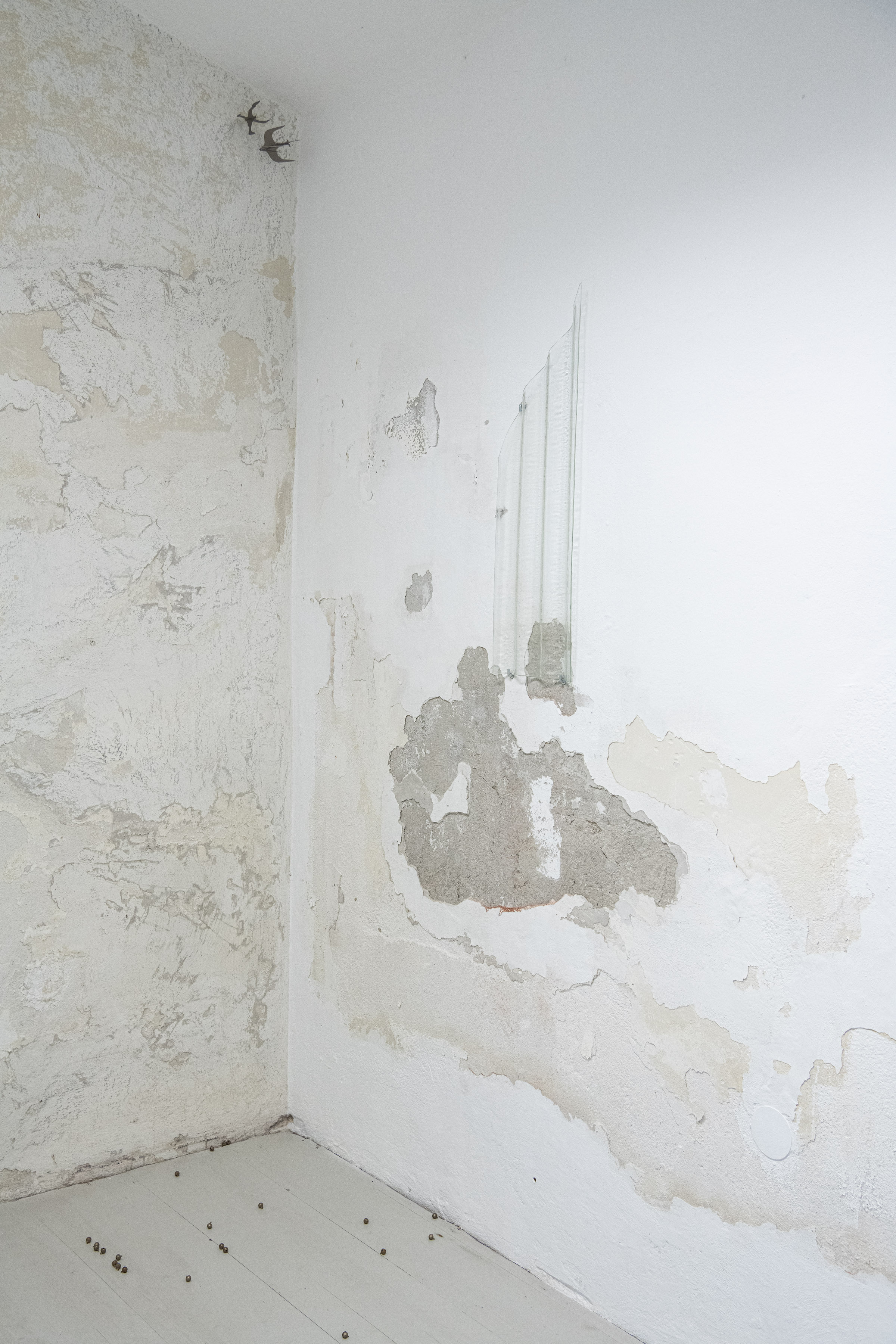 Installation view, Ömer Faruk Kaplan, 'Skins', Floatglas, 80 x 24.5 x 3 cm, 2024, Yixuan Hu, 'ever migrate, ever escape', (“而你心中的鸟群，时时要迁徙，时时要逃避”), Plastic, Compass, 10 x 7 x 7 cm, 11 x 7.7 x 7.7 cm, 2025